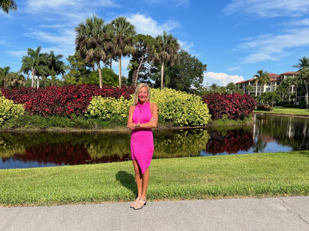 Andrea Hayes standing in front of palm trees and a lake